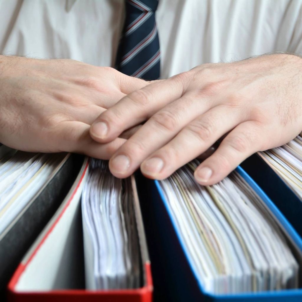 A person in a tie is holding some papers